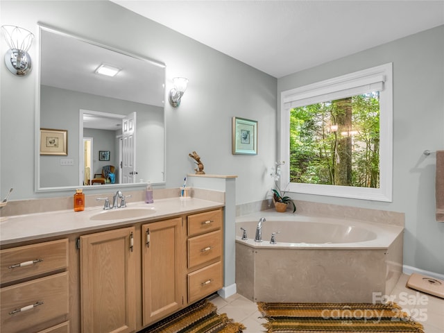 bathroom with tile patterned floors, a bathtub, and vanity