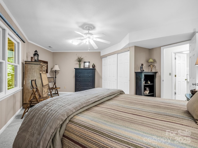 bedroom with carpet flooring, ceiling fan, crown molding, and a closet