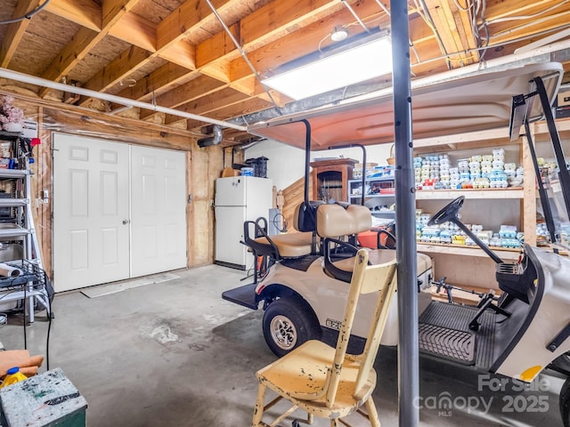 basement featuring a workshop area and white fridge