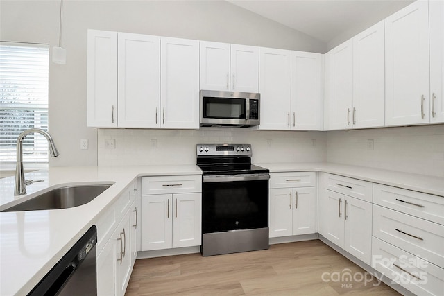 kitchen with sink, white cabinets, and appliances with stainless steel finishes