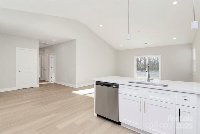 kitchen featuring sink, vaulted ceiling, hanging light fixtures, stainless steel dishwasher, and white cabinets