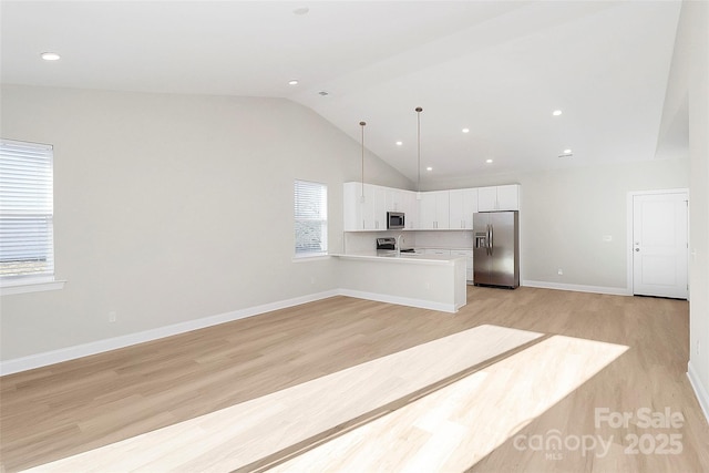 unfurnished living room with high vaulted ceiling and light hardwood / wood-style flooring