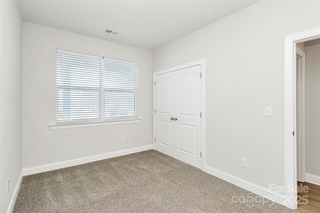 unfurnished bedroom with carpet flooring and a closet