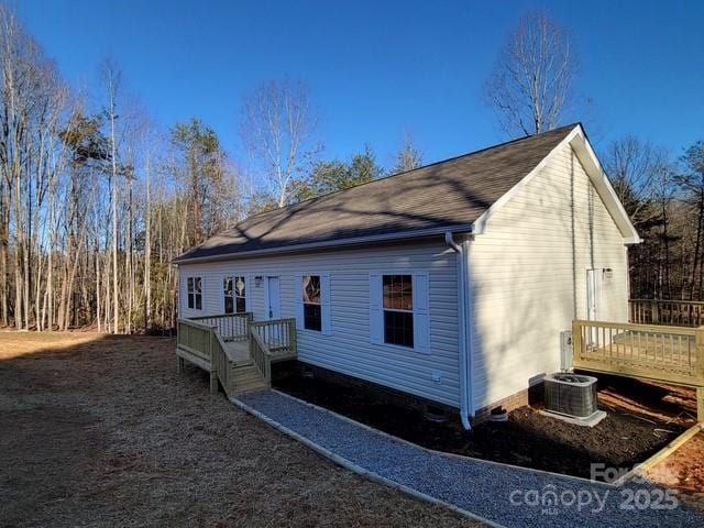 rear view of house with cooling unit and a deck