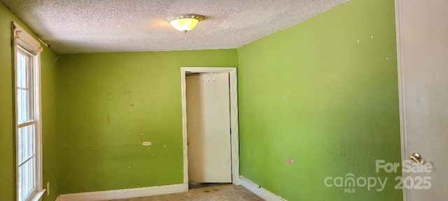 unfurnished bedroom with a textured ceiling and a closet