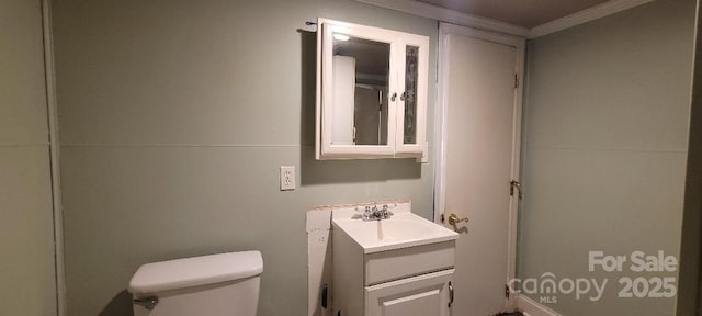 bathroom with crown molding, vanity, and toilet