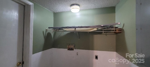 laundry room featuring hookup for an electric dryer, washer hookup, and a textured ceiling