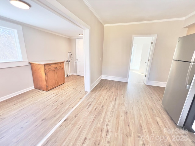 unfurnished dining area featuring ornamental molding and light hardwood / wood-style flooring