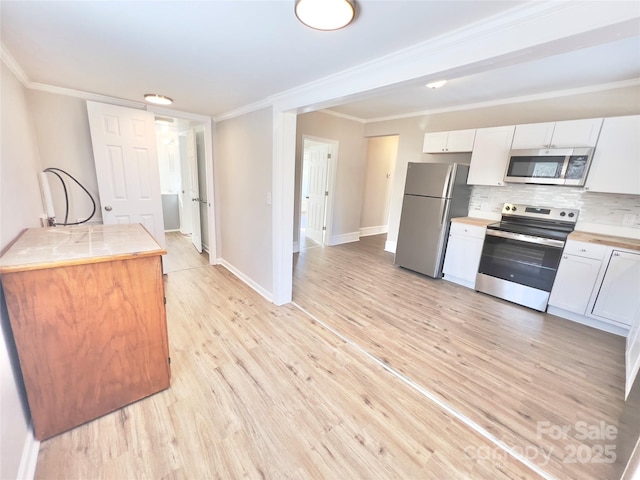 kitchen with white cabinets, decorative backsplash, ornamental molding, and appliances with stainless steel finishes