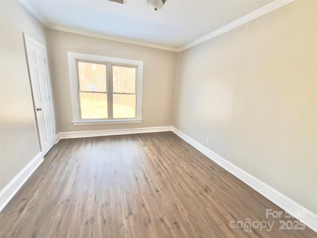 empty room with wood-type flooring and ornamental molding