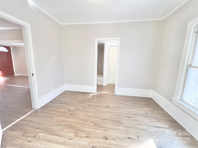 spare room with ornamental molding and light wood-type flooring