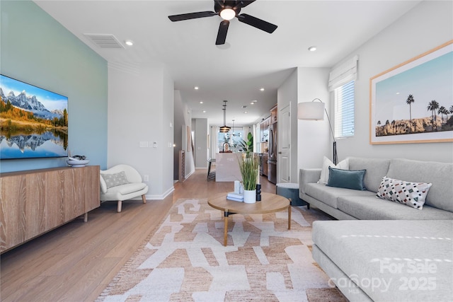 living area with baseboards, light wood-style flooring, visible vents, and recessed lighting