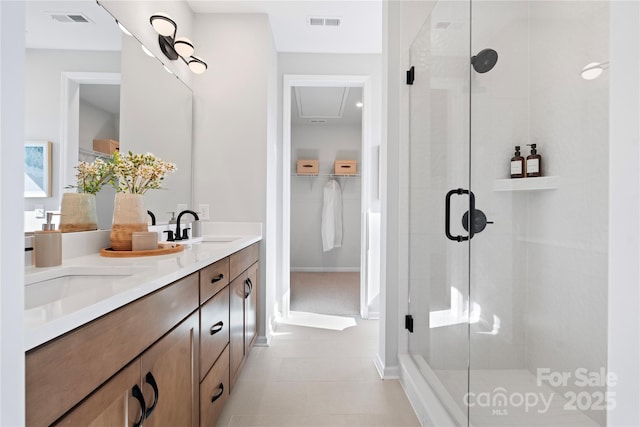 bathroom featuring a stall shower, visible vents, and a sink