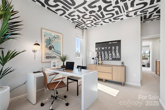 home office featuring light carpet and baseboards