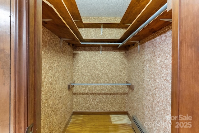 spacious closet featuring a baseboard heating unit