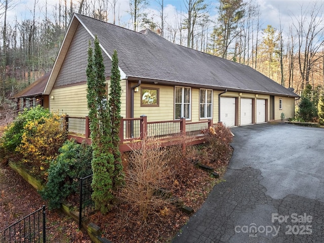 view of front of home featuring a wooden deck and a garage