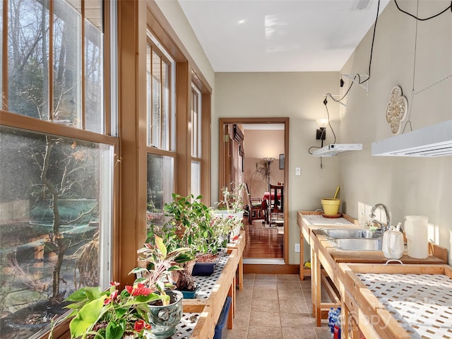 kitchen with light tile patterned floors, butcher block countertops, and sink