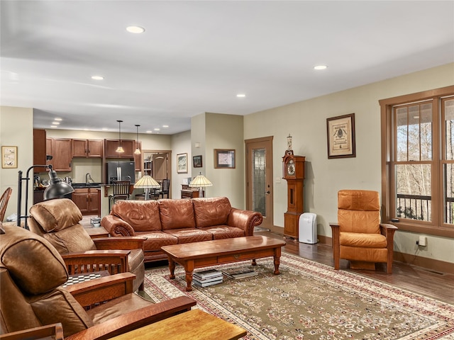 living room with baseboards, wood finished floors, and recessed lighting