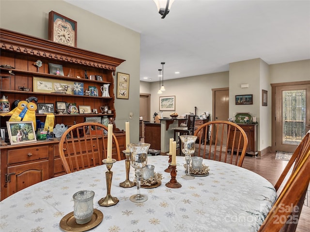 dining space with baseboards and wood finished floors