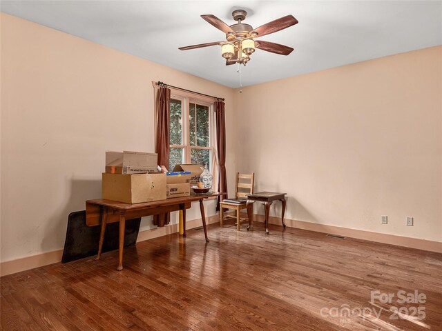 home office with baseboards, wood finished floors, and a ceiling fan