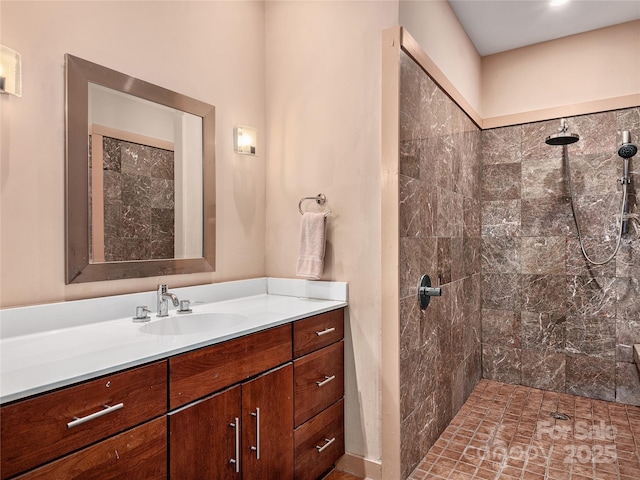 bathroom with vanity and a tile shower