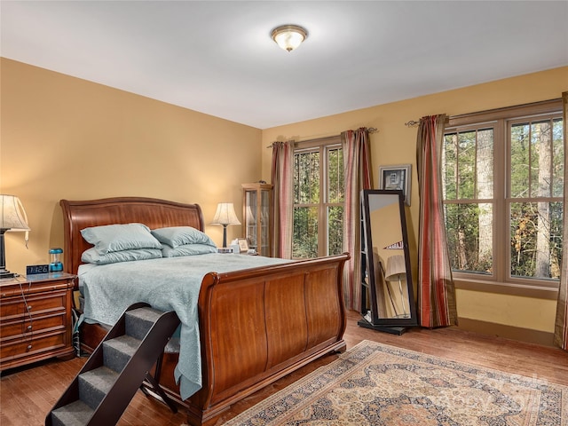 bedroom with baseboards and wood finished floors