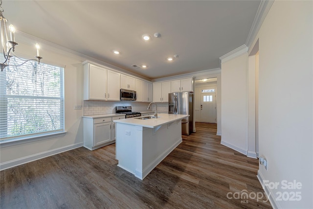 kitchen featuring stainless steel appliances, a kitchen island with sink, white cabinets, dark hardwood / wood-style floors, and hanging light fixtures