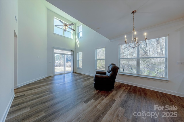 unfurnished room featuring ceiling fan with notable chandelier and dark wood-type flooring