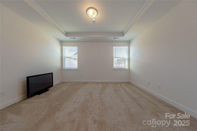 unfurnished room featuring plenty of natural light, crown molding, and a tray ceiling