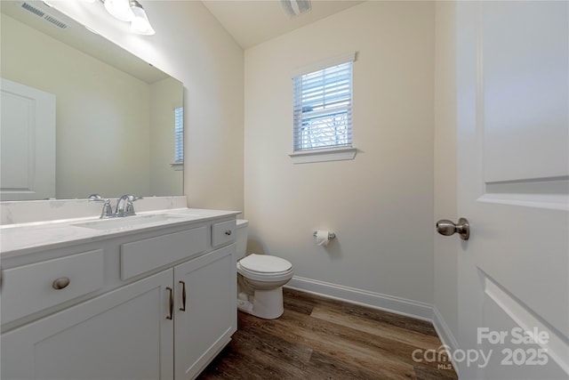 bathroom featuring wood-type flooring, vanity, and toilet