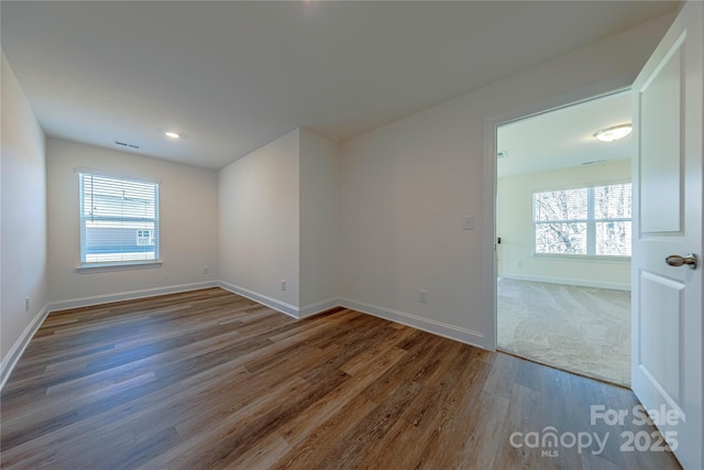 spare room with a healthy amount of sunlight and wood-type flooring