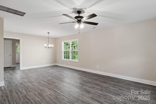 spare room with dark wood-type flooring and ceiling fan with notable chandelier