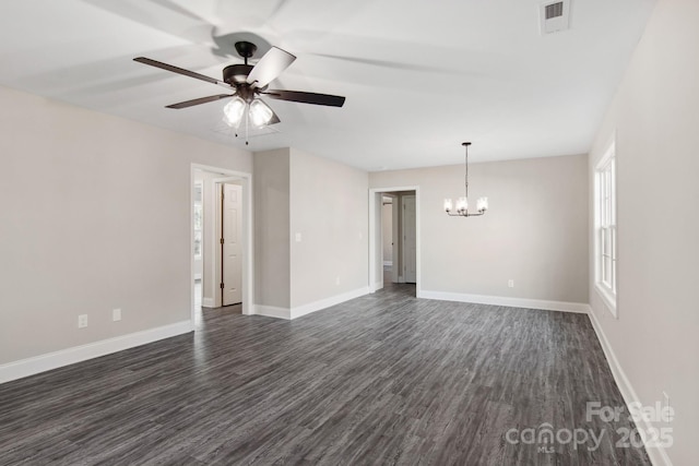 empty room with ceiling fan with notable chandelier and dark hardwood / wood-style floors