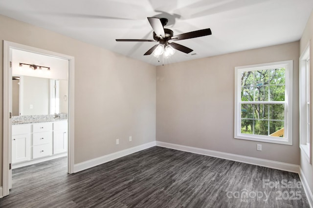 empty room with ceiling fan and dark hardwood / wood-style flooring