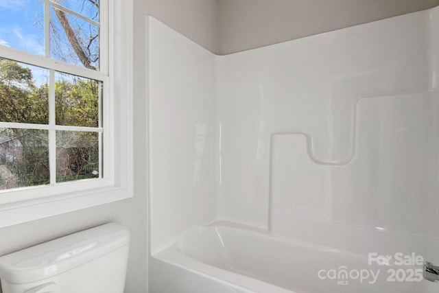 bathroom featuring shower / washtub combination and toilet