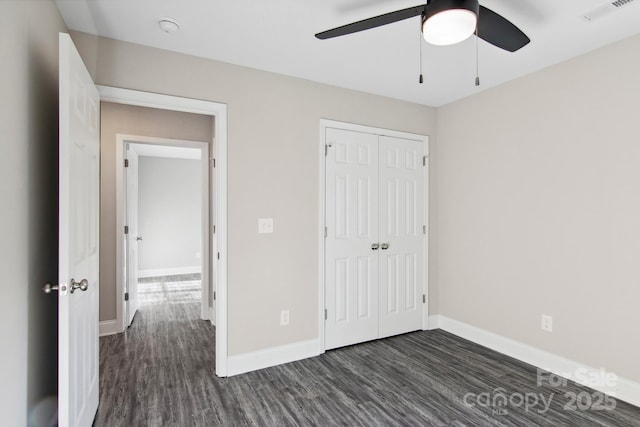 unfurnished bedroom featuring ceiling fan, dark hardwood / wood-style floors, and a closet