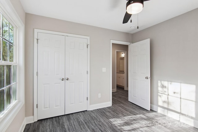 unfurnished bedroom featuring ceiling fan, dark hardwood / wood-style flooring, and a closet