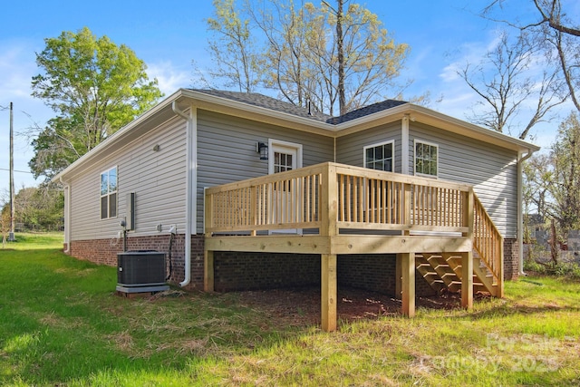 back of property with a wooden deck, a yard, and cooling unit