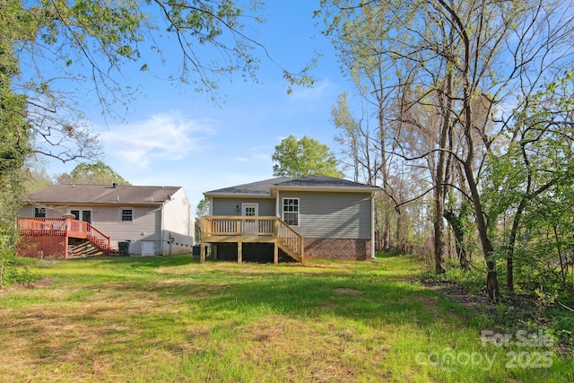 rear view of property featuring a wooden deck and a yard