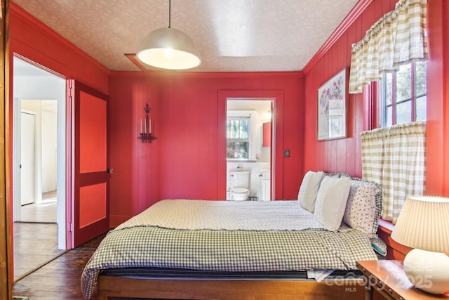 bedroom with multiple windows, crown molding, dark wood-type flooring, and a textured ceiling