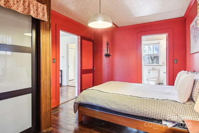 bedroom featuring ornamental molding, dark hardwood / wood-style floors, and a textured ceiling