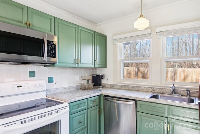 kitchen featuring sink, crown molding, green cabinets, hanging light fixtures, and stainless steel appliances