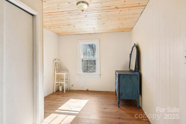 interior space featuring wood walls, light hardwood / wood-style floors, and wooden ceiling