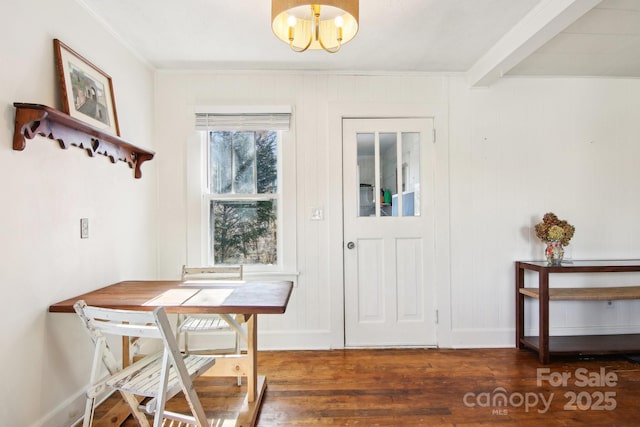 dining space with beamed ceiling, ornamental molding, dark hardwood / wood-style floors, and a chandelier