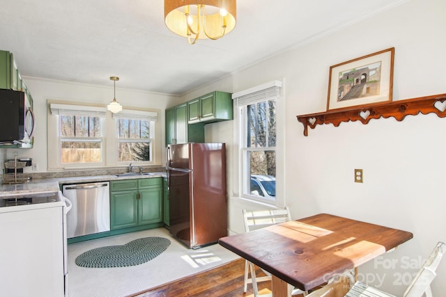 kitchen with sink, green cabinets, hanging light fixtures, stainless steel appliances, and ornamental molding