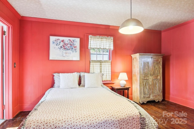 bedroom with ornamental molding, dark hardwood / wood-style floors, and a textured ceiling