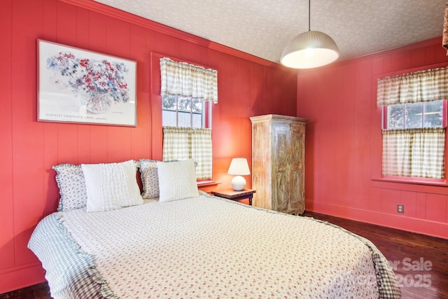 bedroom with dark hardwood / wood-style flooring, ornamental molding, and a textured ceiling