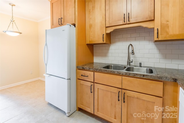 kitchen featuring sink, white refrigerator, light tile patterned flooring, decorative backsplash, and decorative light fixtures