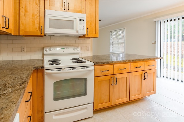 kitchen featuring white appliances, dark stone counters, and backsplash