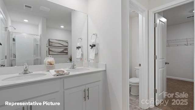 bathroom with toilet, an enclosed shower, and vanity